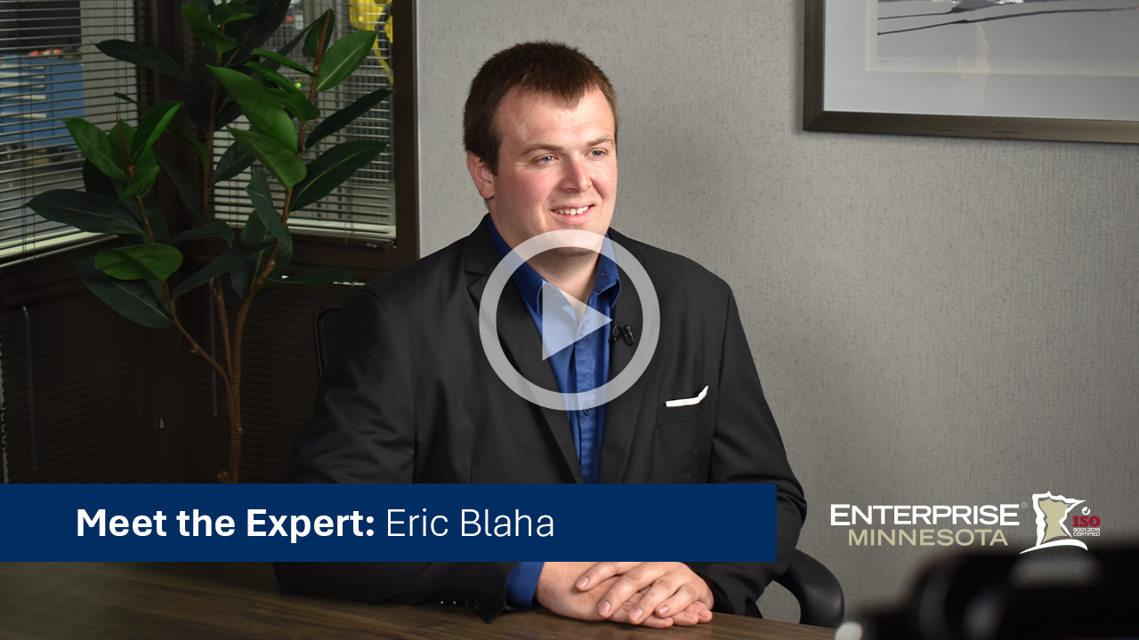 Eric Blaha sitting in a chair. Click to watch his bio video. 
