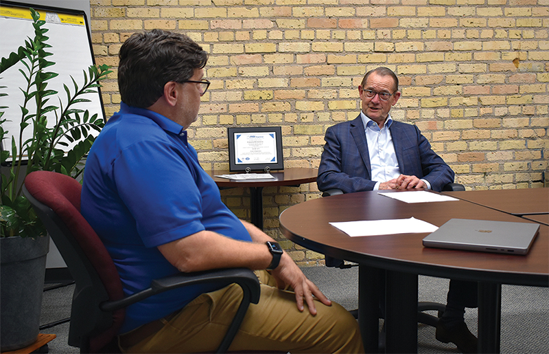 ISO Auditor Tom Paserba speaking with Enterprise Minnesota president Bob Kill. 