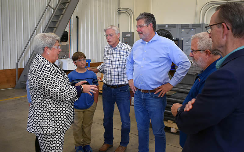 Advanced Coil Technologies owner Sarah Richards speaks with Tim Penny, president of Southern Minnesota Initiative Foundation, and Senator John Jasinski with Devon Barnes and Bob Kill. 